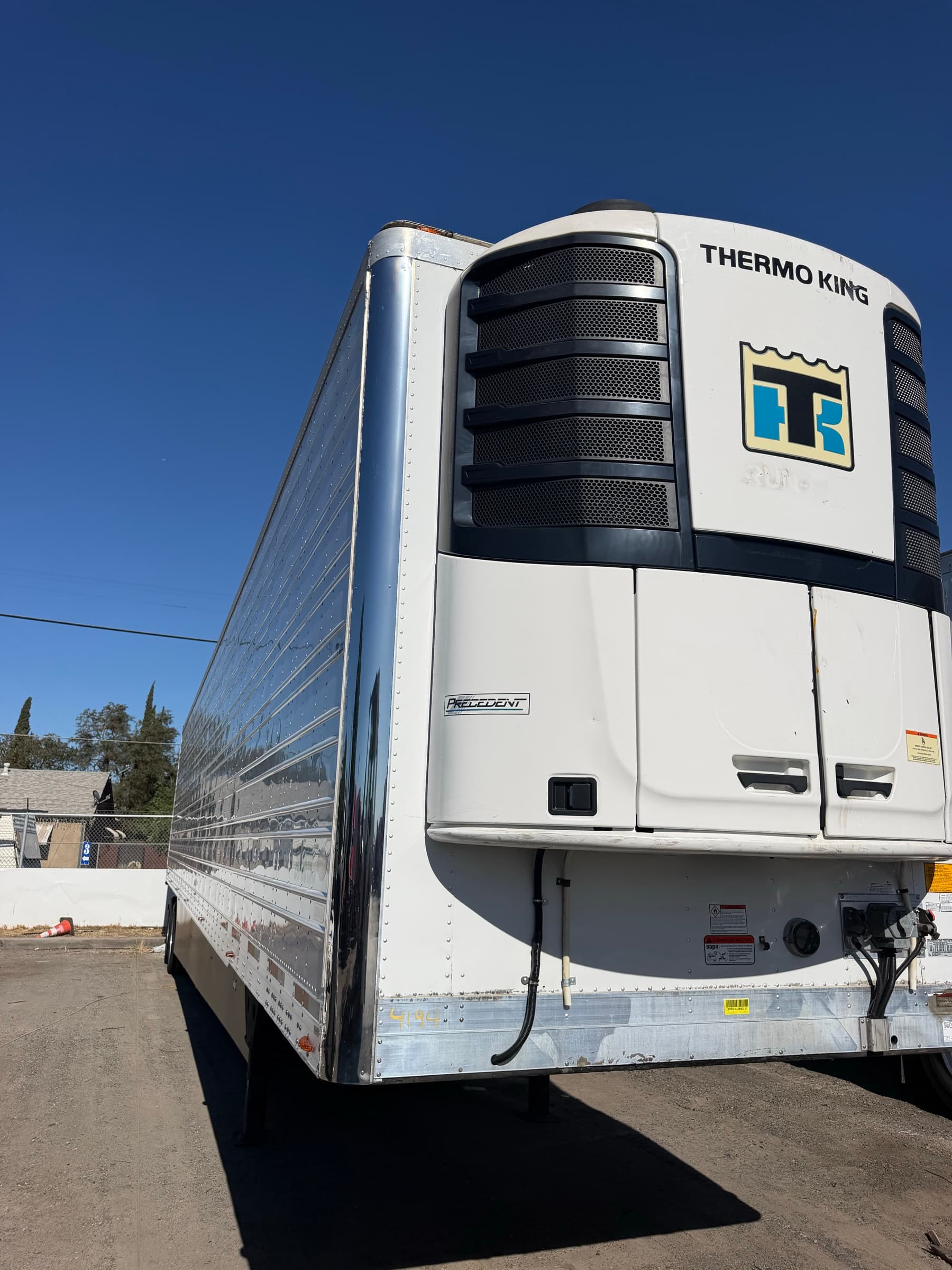 Thermo King refrigeration unit on the nose of a FleetWay reefer trailer against a clear sky